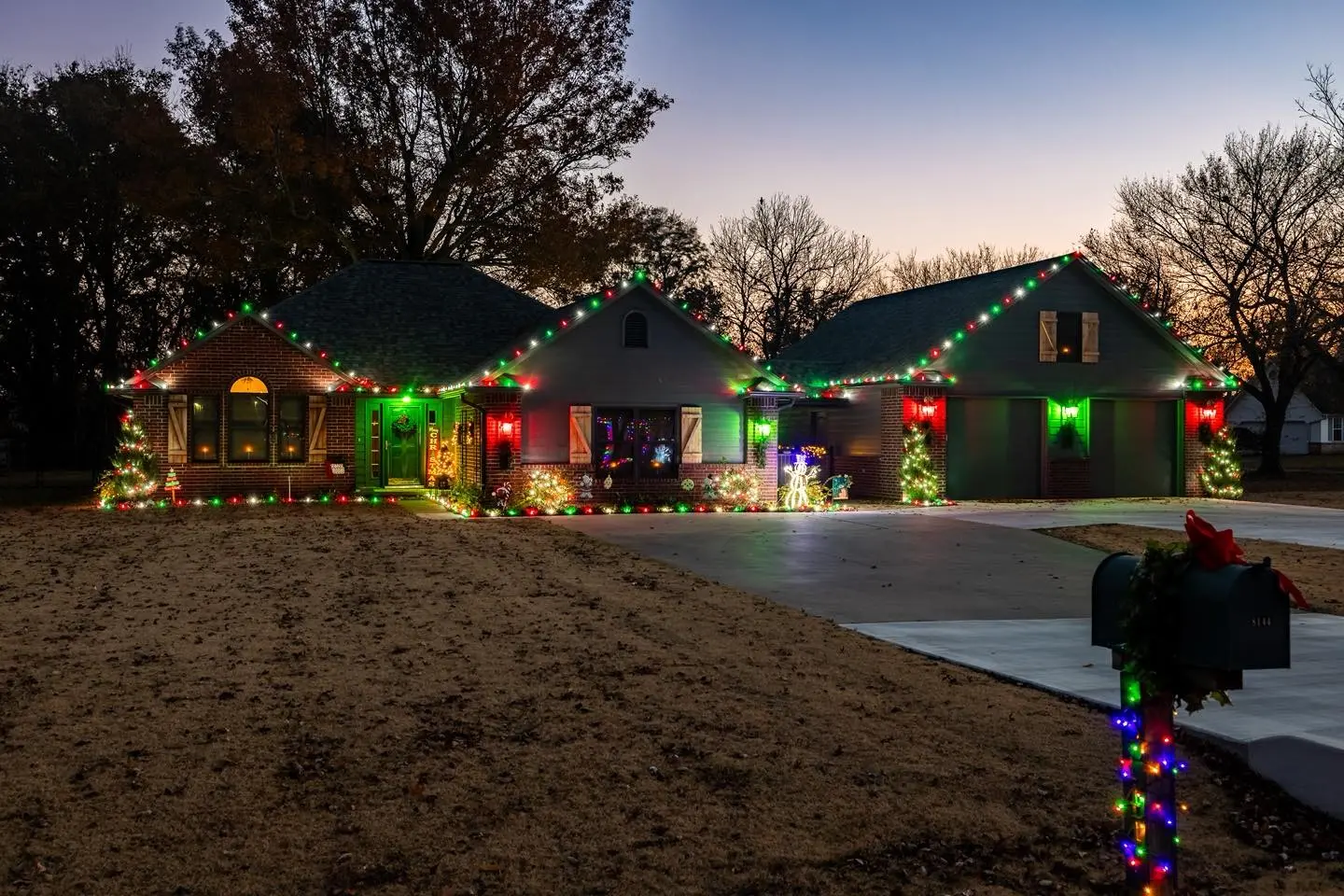 Tulsa brick home lit with red, green and white Christmas lights by Firehouse Custom Lighting